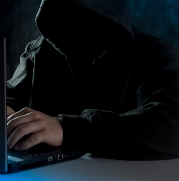 hoody-wearing thief on laptop